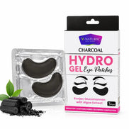 V-Natural Charcoal Hydro Gel Eye Patches shown with their retail box and a blister pack containing two black eye patches, alongside charcoal pieces and green leaves on a white background.