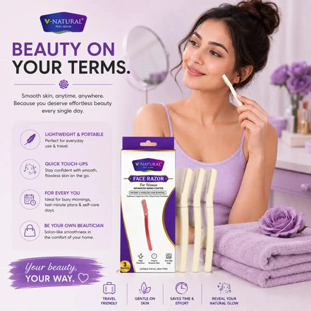 A woman applies a facial razor to her face in a bright, pink-lilac bathroom setting. The product packaging for the V-Natural Face Razor is displayed alongside her, along with three cream-colored razor heads and a purple towel.