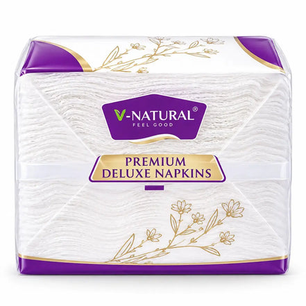 V-Natural Premium Deluxe Napkins in a clear plastic package with purple and gold accents, showing the white textured napkins inside.