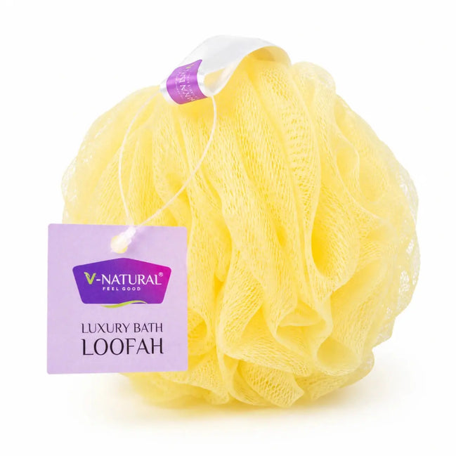Yellow mesh bath loofah with a purple hang tag reading V-Natural Feel Good Luxury Bath Loofah, on a white background.